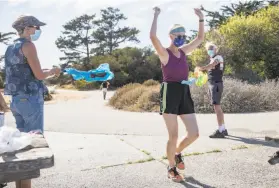  ?? Jessica Christian / The Chronicle ?? Phyllis Gardner and Gordon Priatko hold a ceremonial tape at Candlestic­k Point for the finish of Robin Cohn’s S.F. journey that started in October 2018.