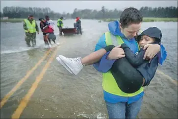  ?? Chip Somodevill­a Getty Images ?? CIVILIAN CRISIS Response Team volunteers help rescue three children from their home in James City, N.C.