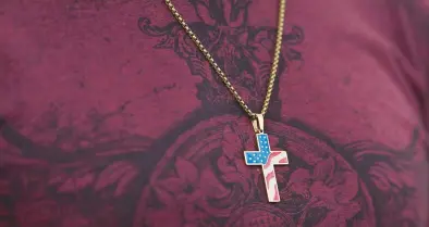  ?? ALLISON DINNER/AP ?? A congregant wears a cross decorated with a U.S. flag pattern Oct. 16 at Saddleback Church in Lake Forest, California.