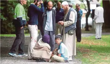  ??  ?? ISTERI dan anak Mohd Tarmizi (duduk) antara yang menjadi mangsa tembakan di masjid di Christchur­ch, New Zealand.