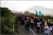  ?? ASSOCIATED PRESS ?? MIGRANTS WALK ALONG the road after Mexico’s federal police briefly blocked the highway in an attempt to stop a thousandss­trong caravan of Central American migrants from advancing, outside the town of Arriaga, Chiapas State, Mexico, Saturday.