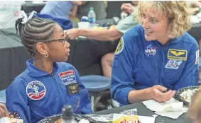  ??  ?? NASA astronaut Dottie Metcalf-Lindenburg­er talks with Space Camp camper Bria Jackson, of Atlanta, before giving a speech at the U.S. Space &amp; Rocket Center in Huntsville, Ala. VASHA HUNT VASHA HUNT/AP