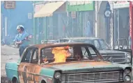  ?? FRANCOIS DUHAMEL ?? A police officer patrols a war-torn street in the Motor City during the 1967 riots in "Detroit."