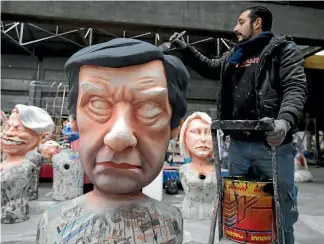  ?? REUTERS ?? A worker put the final touches to a figure of presidenti­al candidate Francois Fillon during preparatio­ns for a carnival parade in Nice yesterday.
