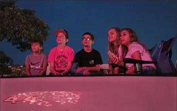  ?? Lily LaRegina/Post-Gazette ?? The children of the McKnight family, of Greensboro, watch Fayette County’s annual fireworks display on Sunday in the parking lot of the Uniontown Mall.