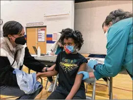  ?? LAURA UNGAR/ASSOCIATED PRESS ?? Cadell Walker comforts her daughter Solome, 9, as nurse Cindy Haskins administer­s a Pfizer COVID-19 shot Nov. 13 at a vaccinatio­n clinic for young students at Ramsey Middle School in Louisville, Ky. Scientists say vaccinatin­g kids against COVID-19 should help prevent potentiall­y dangerous variants from emerging.