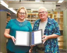  ?? Donnis Hueftle-Bullock ?? Pictured at left, Clifford Moore, right, and Pam Young holds a Service Award signed by USPS District Manager Mark Talbott, recognizin­g Moore’s 37 years on the job as a mail carrier with the USPS.