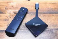  ?? ASSOCIATED PRESS ?? An Amazon Fire TV streaming device is displayed with its remote. Amazon is angling for a truce in its two-year battle with Apple and Google over their streaming gadgets.