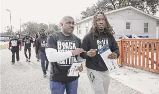  ?? Sait Serkan Gurbuz/Associated Press ?? Artie Armstrong, left, and Joshua Rasheed canvass a neighborho­od in North Charleston, S.C., last month to encourage voting. South Carolina’s Democratic presidenti­al primary was held Saturday.