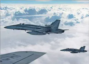  ?? CP PHOTO ?? RCAF CF-18 Hornets depart after refueling over Iraq in this file photo.