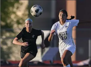  ?? (NWA Democrat-Gazette/Charlie Kaijo) ?? Bentonvill­e’s Ashby Burnett (left) and Rhianna Andrade of Bentonvill­e West chase the ball during Friday’s girls soccer game at the Tiger Athletic Complex in Bentonvill­e. More photos available at nwaonline.com/photo.