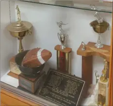  ?? CHRIS LILLSTRUNG — THE NEWS-HERALD ?? League championsh­ip trophies, a football and a plaque adorn an awards display at Newbury. After the school district initiated the process of consolidat­ing with West Geauga last year, this is expected to be the Black Knights’ final season.