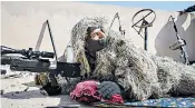  ??  ?? Iraqi artillery, top, fires towards Isil positions in west Mosul. Snipers with the Iraqi federal police, above, are surveying the battlefiel­d ahead of an assault to liberate the city