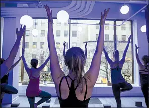  ?? Bloomberg News/VICTOR J. BLUE ?? Customers take a yoga class offered by the Tishman Speyer Properties’ Zo program and app at Rockefelle­r Center in New York in late February.
