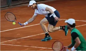  ??  ?? Andy Murray hits a low forehand return as Liam Broady watches on during their win over Max Purcell and Luke Saville. Photograph: Clive Brunskill/Getty Images