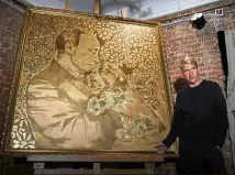  ??  ?? Russia: Artist Alexey Sergienko posing next to his artwork ‘ The Golden Putin’ in Saint Petersburg. He dedicated the painting to President Vladimir Putin for his 65th birthday. — AFP