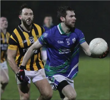  ??  ?? Nigel Usher of Glynn-Barntown about to deliver a handpass as James Gordon (Shelmalier­s) looks on.