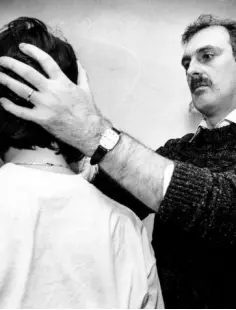  ??  ?? CURING THE SICK: Faith healer Finbarr Nolan lays his hands on a woman’s head in 1974 during one of his healing clinics