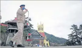  ?? DEEPAK SANSTA /HT ?? A cop making public announceme­nts during corona curfew in Shimla on Friday.