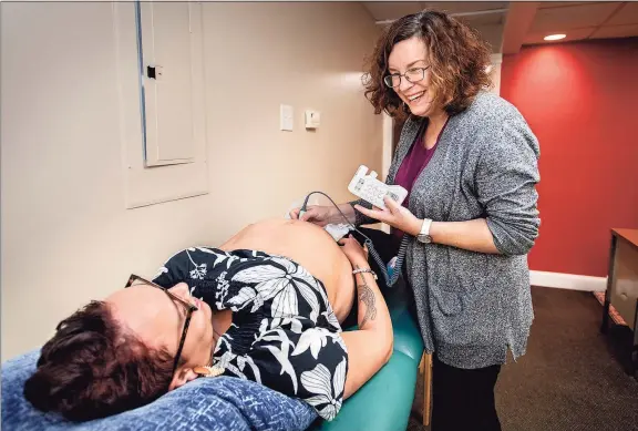  ?? Melanie Stengel / C-Hit ?? Midwife Carolyn Greenfield with client Cameron English at her Rocky Hill office. They are hearing the baby’s heartbeat for the first time. English is from Middletown.