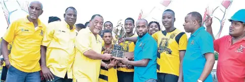  ?? CONTRIBUTE­D ?? Kevon Spence (centre, right), brand manager of Charley’s JB Overproof Rum, presenting coach Marvin Quarrie of Savannah FC with the Charley’s JB Rum Western Confederat­ion Super League Champions’ Cup at a recent presentati­on ceremony. Elated members of...