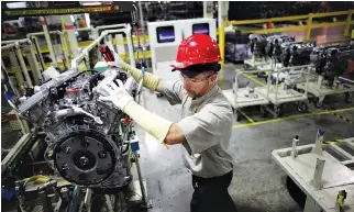  ??  ?? A TOYOTA employee moves an engine at the Toyota engine assembly line in Huntsville, Alabama, Nov. 13, 2009.