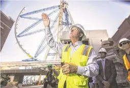  ?? AP ?? The world’s tallest observatio­n wheel, known as the High Roller, is seen behind David Codiga, project director for The Linq, at a constructi­on site in Las Vegas.