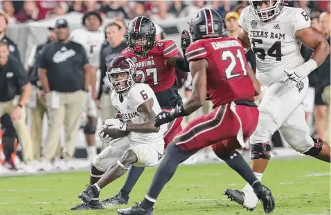  ?? Artie Walker Jr./Associated Press ?? Devon Achane, trying to cut back against South Carolina’s Nick Emmanwori and DQ Smith, gained 99 yards and scored a touchdown.