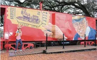  ?? John DeLapp / Correspond­ent ?? Sailor Holubec, 3, helped by mom Leslie, reaches up as if to grab a train ticket at the interactiv­e mural at League City’s League Park. The work by Adam Socie is part of the city’s art initiative.