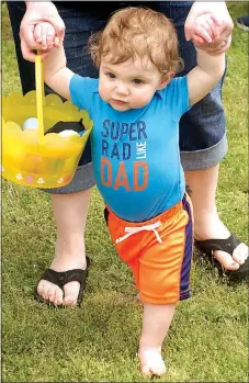  ?? Photo by Randy Moll ?? This youngster was enjoying a barefoot walk in the park grass following the Easter egg hunt in Gentry’s city park on Saturday.