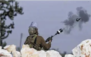  ??  ?? AFP An Israeli soldier fires a tear gas canister at Palestinia­n protesters during a demonstrat­ion in the West Bank village of Budrus. Of the Palestinia­n fatalities since 2005, six were killed by rubber- coated metal bullets and two by tear gas canisters fired at protesters, B’Tselem said.