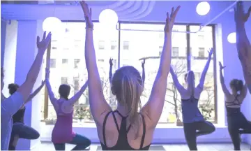  ??  ?? Customers take a yoga class offered by the Tishman Speyer Properties’ Zo programme and app at Rockefelle­r Center.