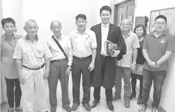  ??  ?? Pujut assemblyma­n Dr Ting (fourth left) with his counsel Ling (fifth left) outside the court room after the ruling. Others are Dr Ting’s family members and party members.