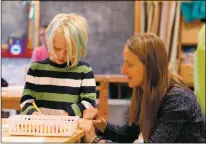  ?? Jesse Moya ?? Taos Integrated School of the Arts teacher Jutka Furesz, right, helps Michael Greeley with a problem before a brief lunch break. TISA is one of the most improved charter schools in Taos, earning an A grade from the state this year.