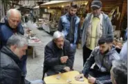  ?? CAIN BURDEAU VIA AP ?? This photo shows vendors of the Vucciria street market in Palermo playing briscola (an Italian card game) on Via Maccherron­ai during the lull of the mid-day lunch hours.
