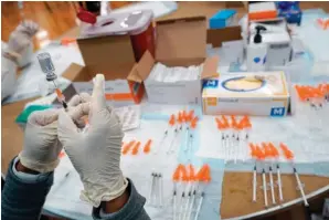  ?? The Associated Press ?? A Northwell Health registered nurses fills a syringe with the Johnson & Johnson COVID-19 vaccine on April 8 at a pop up vaccinatio­n site at the Albanian Islamic Cultural Center in the Staten Island borough of New York. The Biden administra­tion on Wednesday joined calls for more sharing of the technology behind COVID-19 vaccines to help speed the end of the pandemic, a shift that puts the U.S. alongside many in the developing world who want rich countries to do more to get doses to the needy.