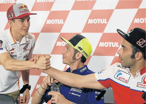  ?? Picture: AFP ?? RIVALS: Yamaha biker Valentino Rossi, centre, of Italy looks at Honda biker Marc Marquez, left, of Spain as he shakes hands with Ducati biker Danilo Petrucci of Italy during a press conference at the Argentina Grand Prix, in Termas de Rio Hondo,...