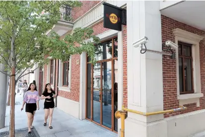  ??  ?? People pass by the closed Hard Rock Cafe on Maoming Road N. yesterday. The Shanghai branch of famed music-themed cafe shut down last week, leaving its employees in limbo. — Wang Rongjiang