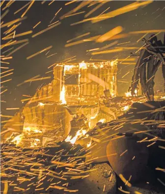  ?? GETTY IMAGES ?? INFERNOS: Windblown embers frame a burning house, above, in Malibu, Calif., on Thursday night.