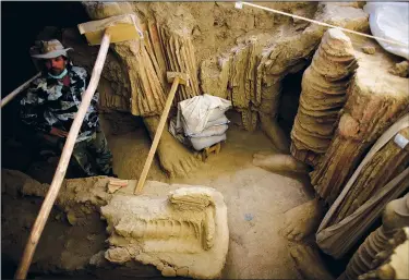  ?? (File Photo/AP/Dusan Vranic,) ?? An Afghan archaeolog­ist stands Oct. 12, 2010, next to remains of Buddha statues discovered inside an ancient temple in Mes Aynak valley, south of Kabul, Afghanista­n.