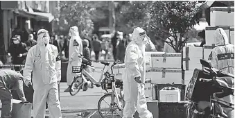  ?? ?? Con trajes protectore­s elementos policiacos salen a las calles de Pekín a pedir a la población • que regrese a sus viviendas.