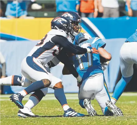  ?? Joe Amon, The Denver Post ?? Broncos outside linebacker Von Miller, left, and defensive end DeMarcus Walker sack Chargers quarterbac­k Philip Rivers on Sunday. Denver raced out to a 17-0 lead and then held on to win 20-13 for its first victory of the season.