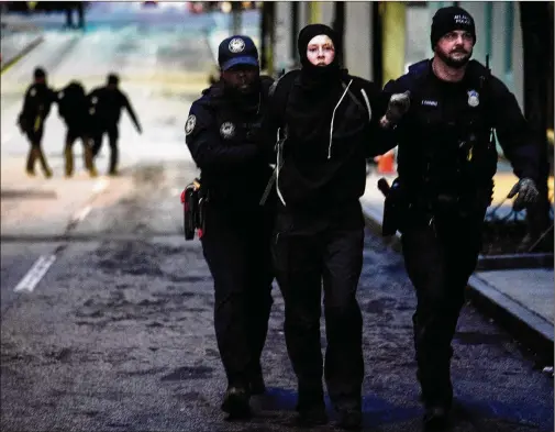  ?? BEN HENDREN FOR THE AJC ?? Forest Defender protesters are arrested during a Jan. 21 rally in which a police car was set afire in Atlanta. Opposition has been both local and national.