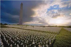  ?? BRYNN ANDERSON/ASSOCIATED PRESS ?? People look at white flags that are part of artist Suzanne Brennan Firstenber­g’s temporary art installati­on, “In America: Remember,” in remembranc­e of Americans who died of COVID, on the National Mall in Washington, D.C.