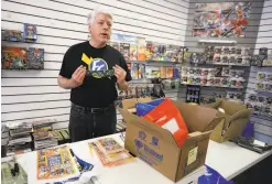  ??  ?? Field prepares to put on his mask before he makes a curbside delivery of comic books at his shop in Concord.