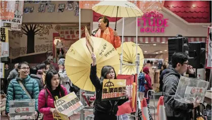  ??  ?? HONG KONG: Demonstrat­ors distribute leaflets before a march for Democracy. — AFP