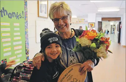  ?? MILLICENT MCKAY/TC MEDIA ?? Greenfield Elementary student Hailie Chaisson gives Gail Finniss a congratula­tory hug. Finniss was recognized for her work as vice-principal and her efforts as organizer for the book and literacy fairs and “going the extra mile”.