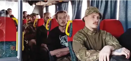  ?? ?? Faces of despondenc­y: Azov fighters, who had hoped to be freed in a prisoner swap, are taken by bus from besieged plant