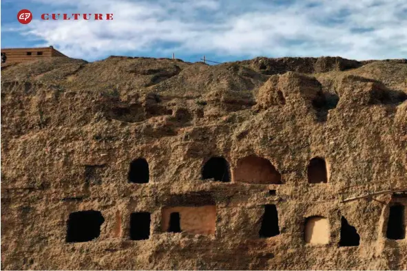  ??  ?? Located on the northern bank of the Danghe River, the Art Center of the Modern Dunhuang Caves features three stories of two dozen windowlike caves in the cliffs, six meters above the semi-dry riverbed.