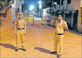  ?? VIPIN KUMAR/HT PHOTO ?? Delhi Police personnel stand guard outside a barricaded lane in Kapashera area, where 41 people of the same building, sealed on April 19, tested positive for the coronaviru­s disease.